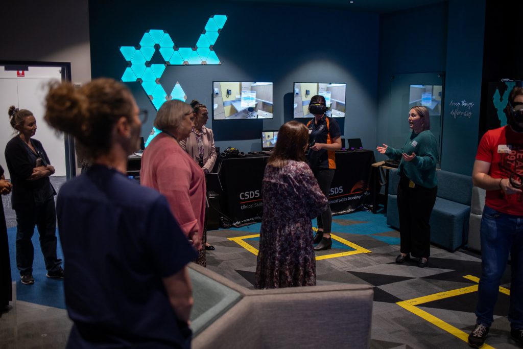 Group of people watches a demo of virtual reality technology by Cassie Smith, Casey Lambert, and Dean Gray.